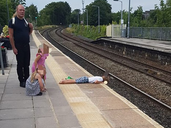 A sínek fölé feküdt a kisfiú a vasútállomáson, az apukája meg csak nézte! - Szerinte nem volt veszélyben a fia