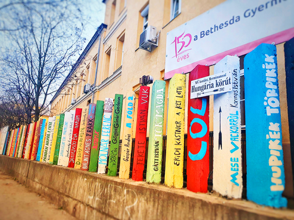 Így lett színes könyvespolc a mogorva betonkerítésből a Bethesda Gyermekkórház előtt - Szuper ötlet a költészet napjára